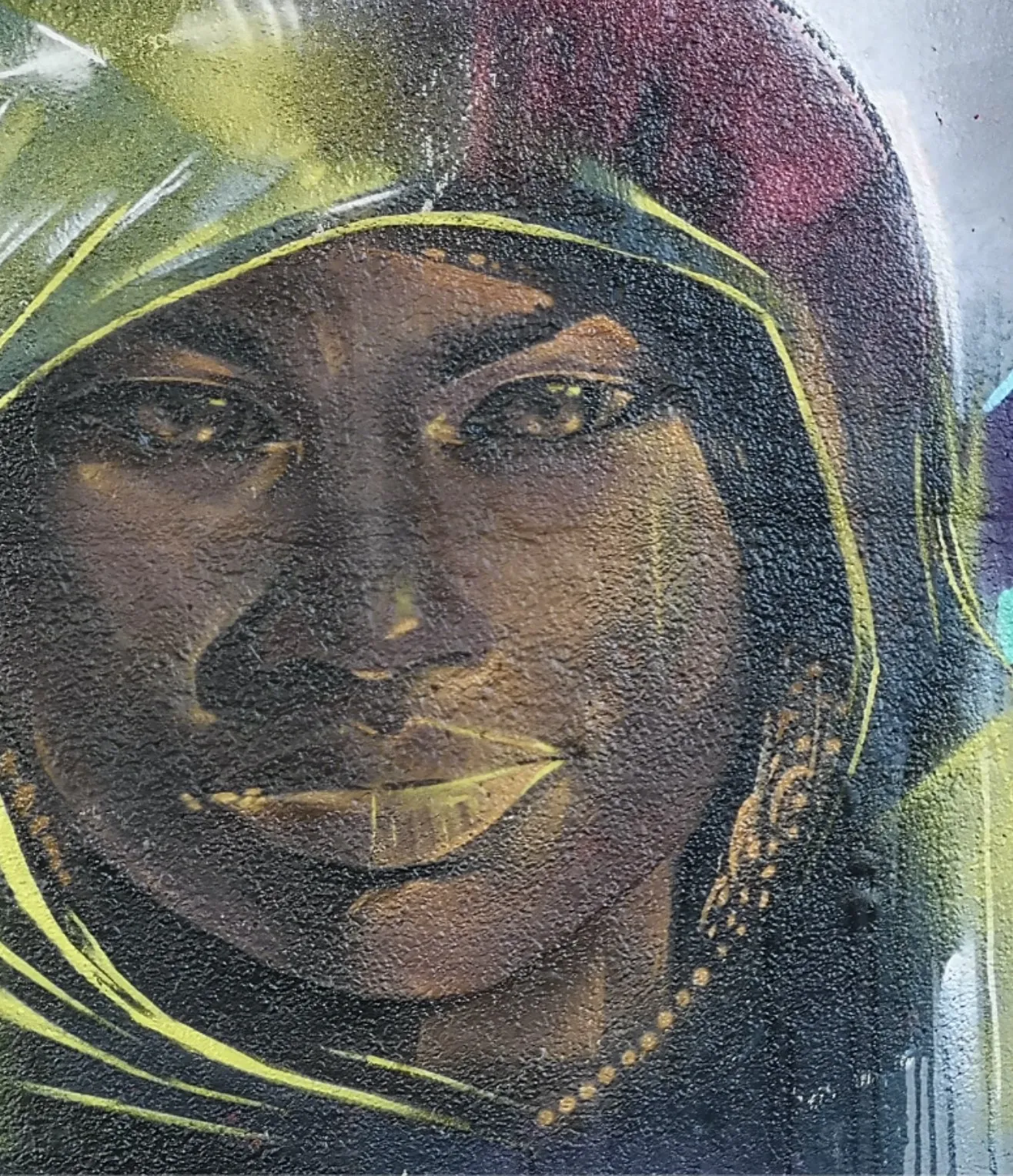 Portrait mural of a woman in a hooded scarf, painted in muted greens and golds